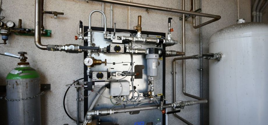 Impianto per la distribuzione di gas tecnici con bombola, serbatoio, tubazioni metalliche, valvole, riduttori di pressione e dispositivi di controllo per una gestione sicura e regolata dei gas.