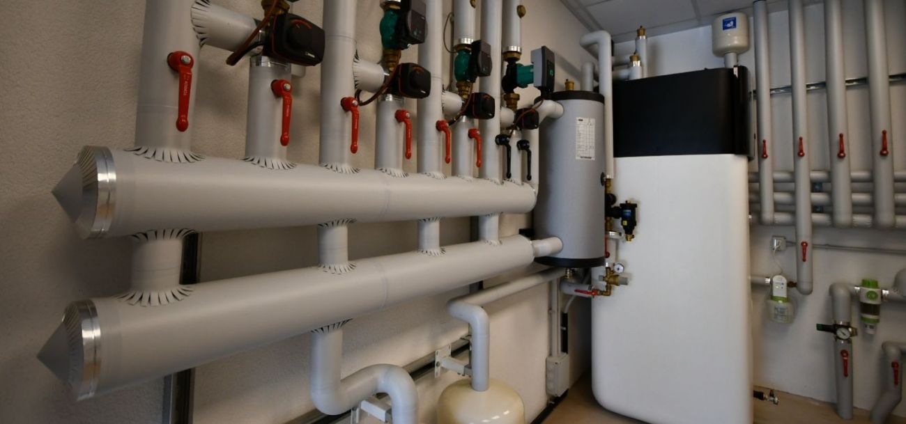 Locale tecnico con impianto idrico-sanitario composto da tubazioni coibentate, collettori, valvole, pompe e serbatoi per la distribuzione, regolazione e gestione dell’acqua sanitaria.
