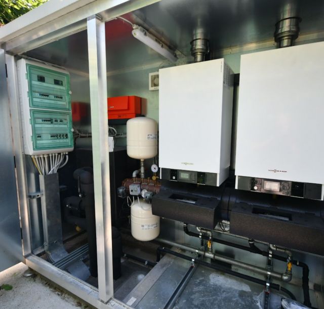 Locale tecnico con due caldaie murali, quadro elettrico, vasi di espansione, tubazioni e dispositivi di regolazione per la gestione dell’impianto termico.