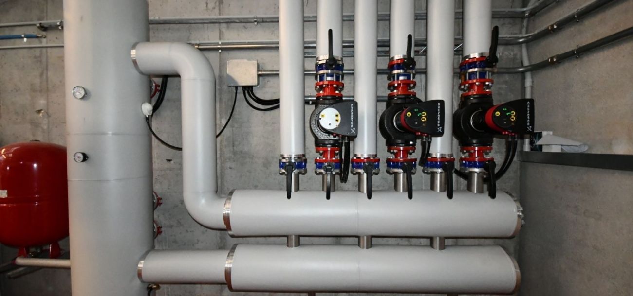 Impianto industriale con tubazioni coibentate, collettori, pompe di circolazione e valvole per la distribuzione e la gestione dei fluidi tecnici.